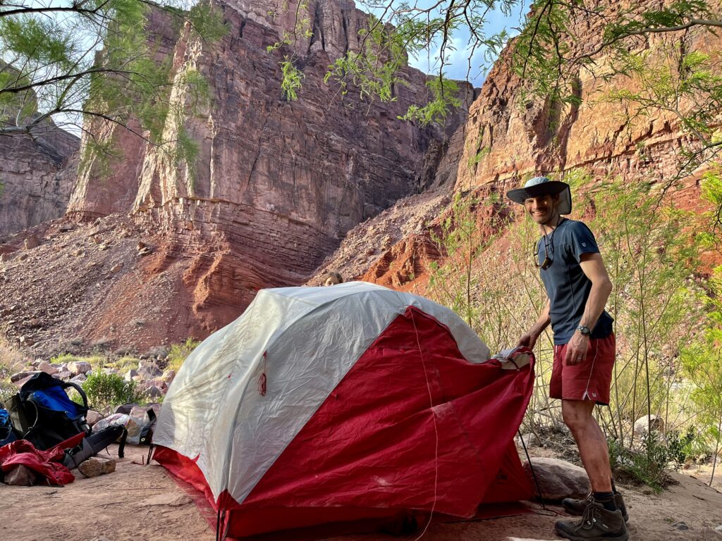 Man sets up a tent in the Grand Canyon.