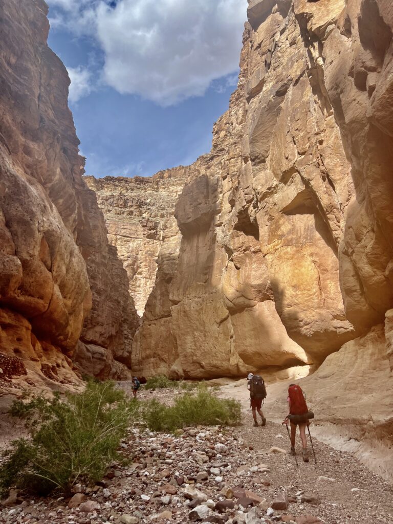 Hikers walk through a slot canyon at 75-Mile Creek.