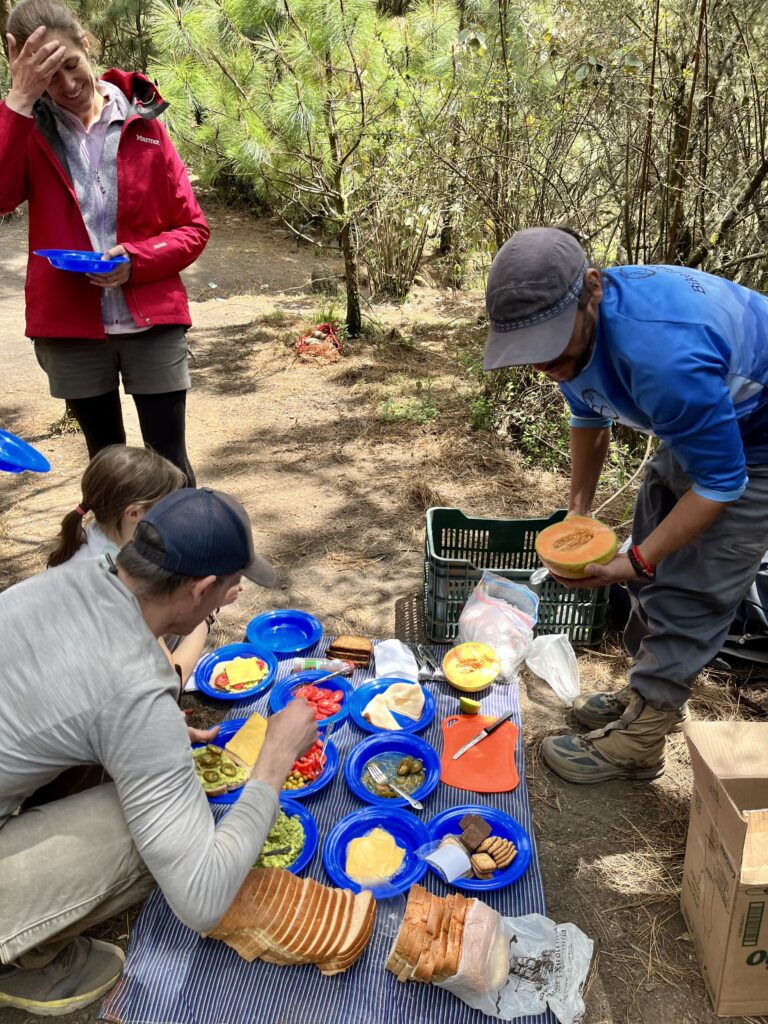 A guide distributes lunch to hungry hikers.