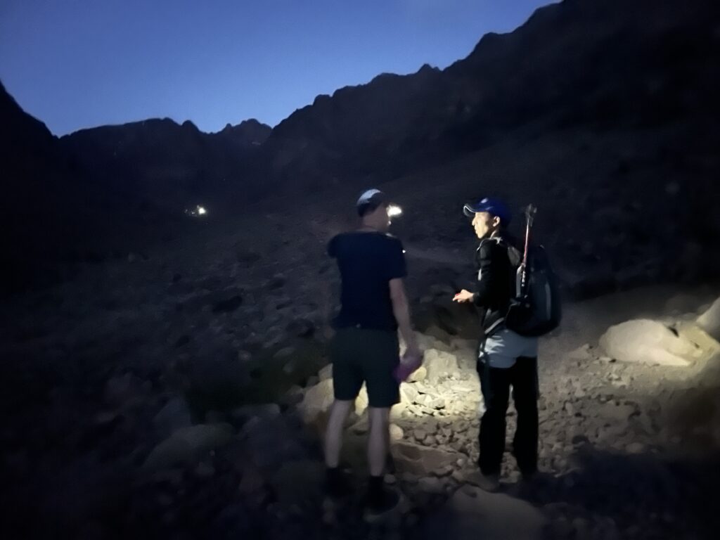 A guide and a climber converse in the early hours of the morning.