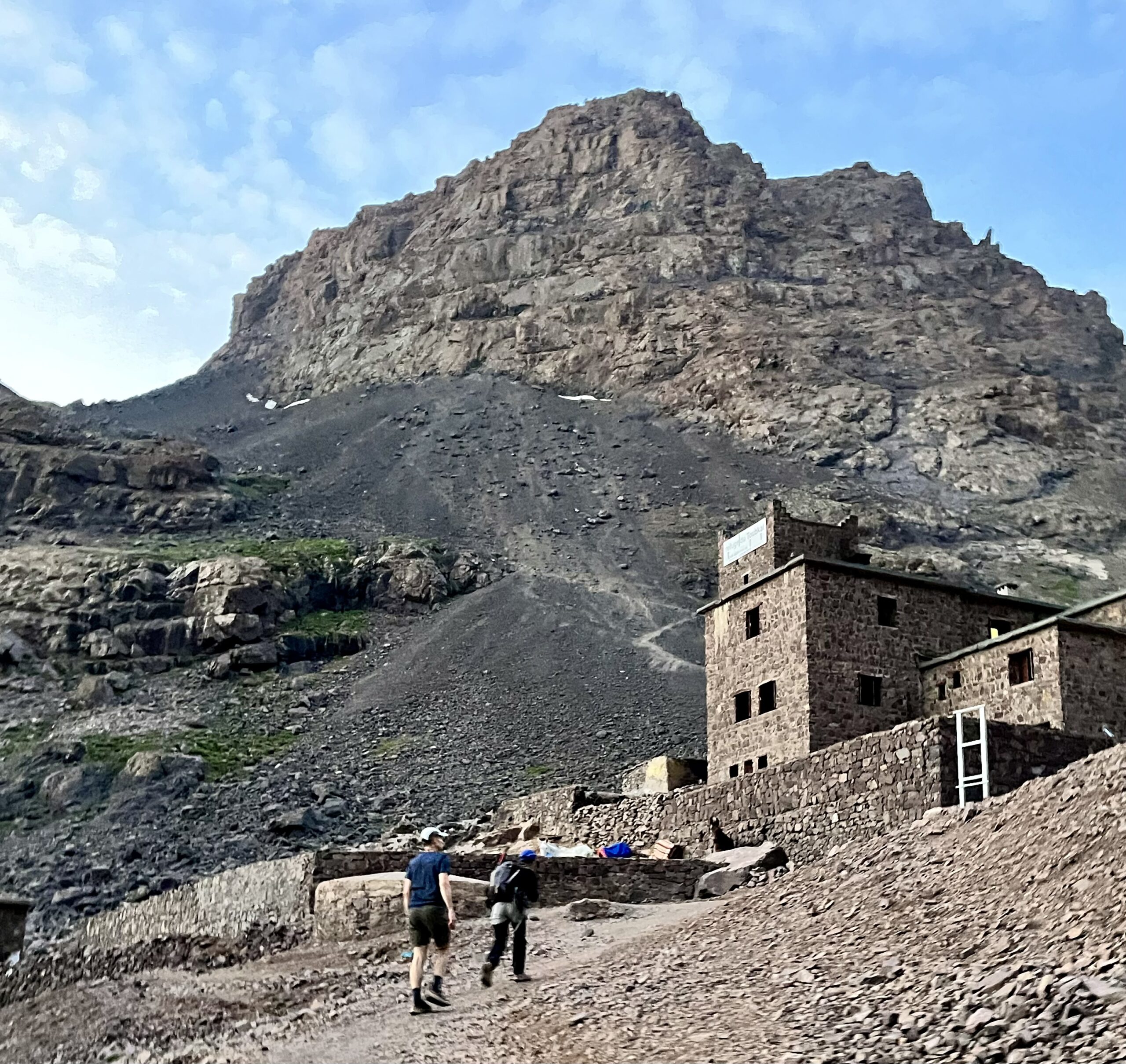 Hikers approach a mountain refuge.