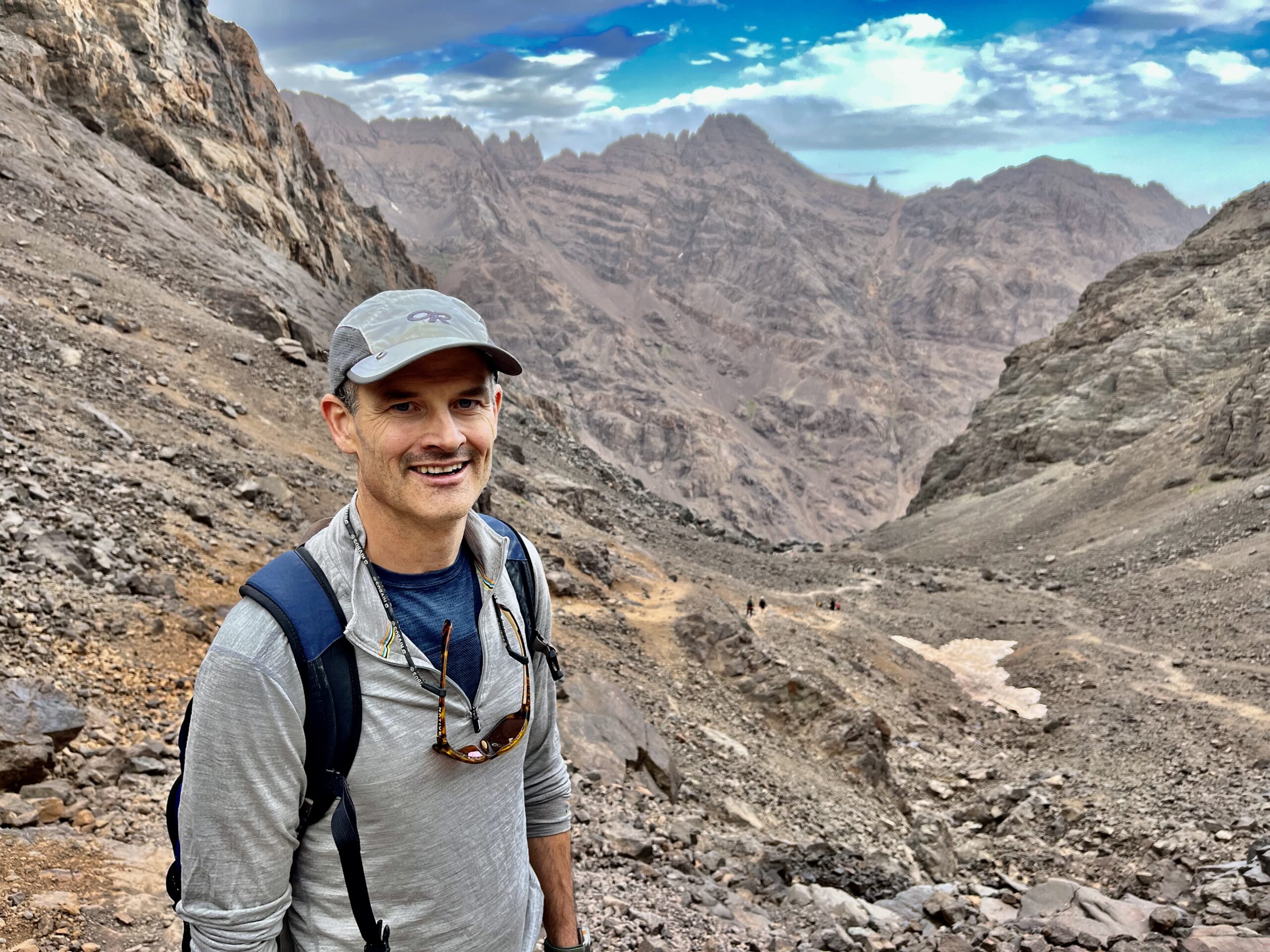 A man smiles with a majestic canyon as the backdrop.