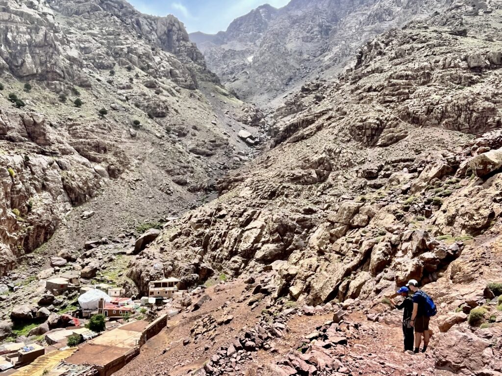 A guide directs a hiker through a canyon on Jbel Toubkal.