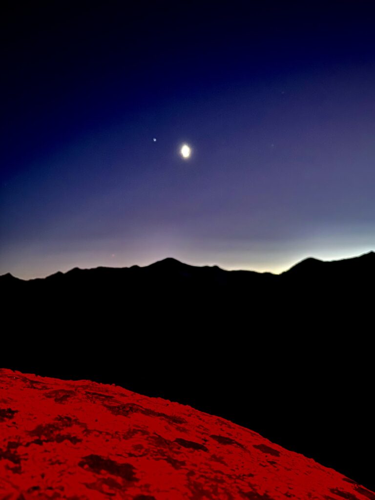 Red headlamp light on a rock.